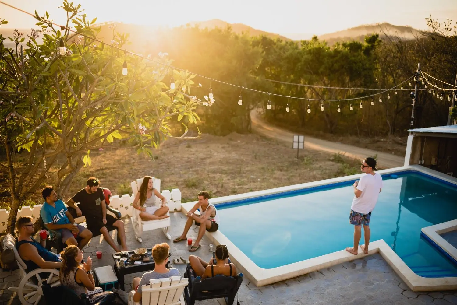 A group of remote workers gathered poolside at golden hour, Nicaragua