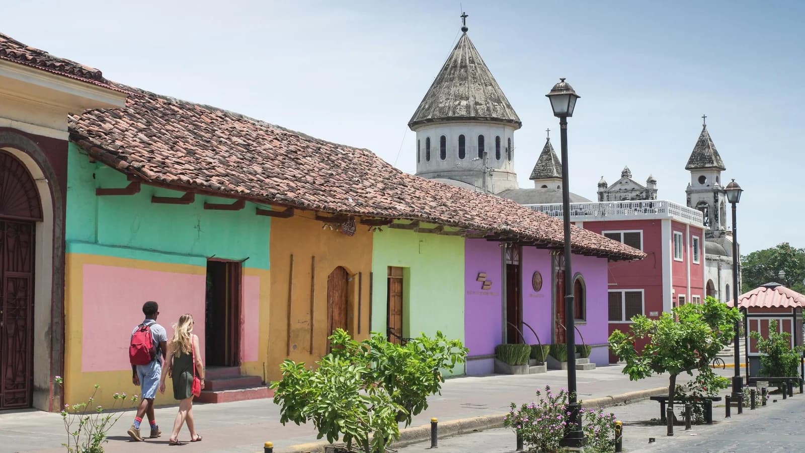 Couple walking through the colorful colonial streets of Granada, Nicaragua, in daylight